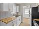 Renovated kitchen featuring white cabinetry, butcher block countertops, and stainless steel appliances at 1836 N Riley Ave, Indianapolis, IN 46218