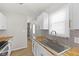 Updated kitchen with white cabinets, butcher block countertops, stainless sink, and stylish backsplash at 1836 N Riley Ave, Indianapolis, IN 46218