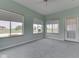 Bright sunroom with three large windows, carpet, and a door leading to the outside at 1873 S 510 E, Franklin, IN 46131