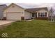 Inviting single-story home with a two-car garage, green lawn, and attractive landscaping at 2179 W Van Arsdall Ct, Columbus, IN 47201