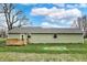 Expansive shot of the back exterior showcasing the well-kept lawn, wood deck, and clean siding at 2264 Walnut W St, Greenfield, IN 46140
