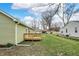 Exterior shot of the back of the home, featuring a new deck, green grass, and mature trees at 2264 Walnut W St, Greenfield, IN 46140
