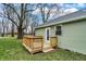 Back exterior shot of the home featuring a new deck, green grass, and mature trees at 2264 Walnut W St, Greenfield, IN 46140
