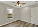 This bedroom features wood-look floors, a ceiling fan, and a large window at 2264 Walnut W St, Greenfield, IN 46140