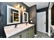 Modern bathroom featuring double sinks with black fixtures, decorative mirrors, and stylish black and white flooring at 260 Christina Dr, Whiteland, IN 46184