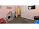 Bright bedroom featuring a TV, a colorful storage shelf, a pink wall, and a doorway leading to the next room at 260 Christina Dr, Whiteland, IN 46184