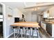 Bright kitchen featuring a breakfast bar, white cabinetry, stainless steel appliances, and gray vinyl plank flooring at 260 Christina Dr, Whiteland, IN 46184