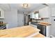 Modern kitchen with stainless steel appliances, a farmhouse sink, white cabinets, and butcher block countertops at 260 Christina Dr, Whiteland, IN 46184