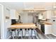 Bright kitchen featuring a breakfast bar, white cabinetry, stainless steel appliances, and gray vinyl plank flooring at 260 Christina Dr, Whiteland, IN 46184
