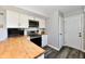 Bright kitchen featuring a breakfast bar, white cabinetry, stainless steel appliances, and gray vinyl plank flooring at 260 Christina Dr, Whiteland, IN 46184