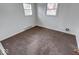 Bright bedroom features neutral walls, carpet, and two windows at 268 E Hoover Dr, Princess Lakes, IN 46164