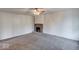 Spacious living room with a ceiling fan, neutral carpet, and a stone fireplace providing a cozy ambiance at 268 E Hoover Dr, Princess Lakes, IN 46164