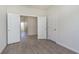 Well-lit bedroom with wood-look flooring, white trim and doors, and an open doorway to the hallway at 2766 Ruffian Dr, Westfield, IN 46074