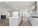 Open concept kitchen with a white island, stainless steel appliances, and hardwood floors next to a fireplace at 2766 Ruffian Dr, Westfield, IN 46074
