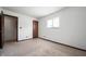Spacious bedroom with a window, carpet, standard electrical outlets, and a wooden door at 2804 Paso Del Norte Dr, Indianapolis, IN 46227