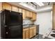 Kitchen featuring black refrigerator, double sink, and stove beneath light wooden cabinetry at 2804 Paso Del Norte Dr, Indianapolis, IN 46227