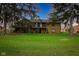 Spacious backyard view of a stone house with a deck overlooking the green golf course at 3037 Santiago Dr, Greenwood, IN 46143