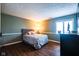 Bedroom with wood flooring, queen bed, modern lamp, and large window for natural light at 3037 Santiago Dr, Greenwood, IN 46143