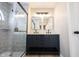 A modern bathroom featuring a dark blue double vanity, walk-in shower, and neutral wall paint at 3260 Eddy Ct, Indianapolis, IN 46214
