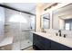 Modern bathroom featuring double vanity with black hardware and tiled walk-in shower with bench and arched window at 3260 Eddy Ct, Indianapolis, IN 46214