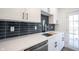 Modern kitchen boasts sleek white cabinetry, quartz countertops, and stylish dark backsplash at 3260 Eddy Ct, Indianapolis, IN 46214