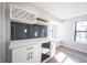 Wet bar in the kitchen features sleek white cabinetry, dark backsplash, built-in wine fridge, and a quartz countertop at 3260 Eddy Ct, Indianapolis, IN 46214