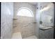 Tiled shower featuring tiled bench, corner shelves and arched window providing natural light at 3260 Eddy Ct, Indianapolis, IN 46214