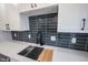Kitchen sink area with quartz counters, black faucet and hardware, and dark tiled backsplash at 3260 Eddy Ct, Indianapolis, IN 46214