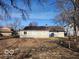 Large backyard view showing the home's exterior, mature trees, and ample space for outdoor activities at 3844 Esquire Ct, Indianapolis, IN 46226
