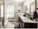 Bathroom with double sinks, decorative mirrors, and gray wood-style flooring, exuding modern elegance and comfort at 421 S East St, Plainfield, IN 46168