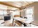 Bright dining area features a wooden table, bench, and view of the open kitchen with stainless steel appliances at 421 S East St, Plainfield, IN 46168