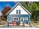 Charming home exterior featuring a blue facade, gabled roof, and a spacious deck with outdoor seating at 421 S East St, Plainfield, IN 46168
