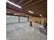 Extensive garage featuring concrete floors, unfinished walls, wood beam ceiling, and two overhead doors with windows at 421 S East St, Plainfield, IN 46168