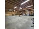 Large garage interior showing concrete floor, unfinished walls, and a wood beam ceiling with abundant storage options at 421 S East St, Plainfield, IN 46168