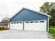 Spacious two-car garage with white doors and ample parking space, set against a blue exterior at 421 S East St, Plainfield, IN 46168