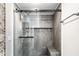 Modern shower featuring gray stone tile, glass enclosure, mosaic tile accents, and a convenient built-in bench at 421 S East St, Plainfield, IN 46168