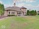 View of the brick house with a backyard patio and green lush grass at 443 Mclaren Ln, Carmel, IN 46032