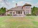 View of the brick house with a backyard patio and garden at 443 Mclaren Ln, Carmel, IN 46032