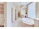 Bright bathroom with a soaking tub, dual sink vanity, and tile flooring at 443 Mclaren Ln, Carmel, IN 46032