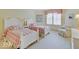 Cozy bedroom with two twin beds featuring matching plaid bedding and a comfortable reading chair at 443 Mclaren Ln, Carmel, IN 46032