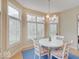 Bright breakfast nook featuring a chandelier, white table and chairs, and lots of windows at 443 Mclaren Ln, Carmel, IN 46032