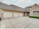 Expansive driveway leads to a three-car garage of a brick home under a cloudy sky at 443 Mclaren Ln, Carmel, IN 46032