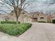 Charming brick home featuring a well-manicured lawn and an expansive driveway with a three-car garage at 443 Mclaren Ln, Carmel, IN 46032