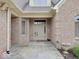 Welcoming front entrance of brick home, featuring stone walkway, neutral door, and manicured landscaping at 443 Mclaren Ln, Carmel, IN 46032