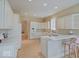 Well-lit kitchen with white cabinets, modern appliances, and a convenient breakfast bar at 443 Mclaren Ln, Carmel, IN 46032