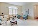 Comfortable living area showcasing a beige L-shaped couch, two teal chairs and a circular wood table at 443 Mclaren Ln, Carmel, IN 46032