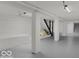 Unfinished basement featuring painted floors, support beams, and staircase to upper level at 46 N Denny St, Indianapolis, IN 46201