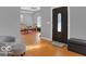 Welcoming entryway with hardwood floors leading to the living room, dark wood door, and neutral decor at 46 N Denny St, Indianapolis, IN 46201
