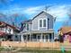 Charming two-story home featuring a blue exterior, white trim, fenced yard, and a welcoming front porch at 46 N Denny St, Indianapolis, IN 46201
