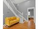 Entryway with a yellow sofa and staircase leading upstairs at 46 N Denny St, Indianapolis, IN 46201